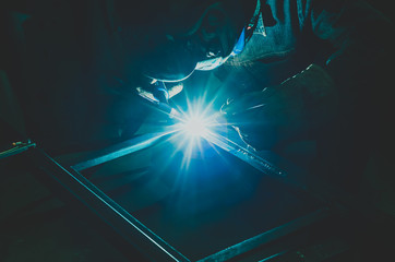 Welding a metal product in a metal workshop.