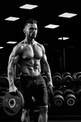 Fototapeta na wymiar Monochrome portrait of bodybuilder carrying weights.