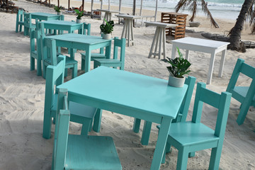 Tables et chaises bleues dans le sable