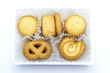 Variety Christmas Danish style butter cookies biscuit placed in the white ruffled paper baking molds in the plastic packaging close-up on white background. Snack for Season's greetings.
