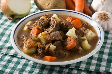 Irish beef stew with carrots and potatoes on wooden table