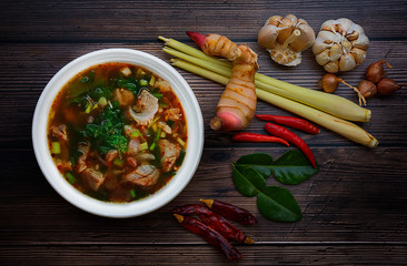 Pork spare rib Spicy soup white plate circle on dark wood and food flavoring Thai cuisine