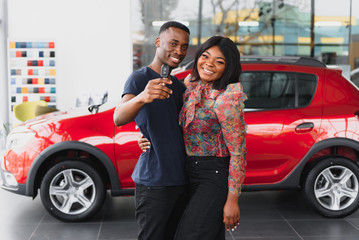 young african couple buying new car at dealership