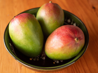 Delicious three mango are in a bowl on the table