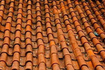 Prague. 05.10.2019: Low light detail of patina red roof top. Prague Lesser Town typical roofing material. Old roofing of clay tiles. Various orange shades and stains.
