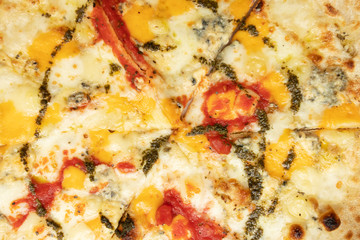 Harmful fatty non-dietary food. Four cheese pizza with pesto and tomato.