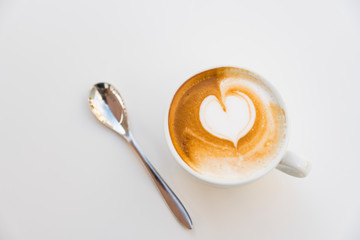 Spoon, cappuccino with heart shape, on white background