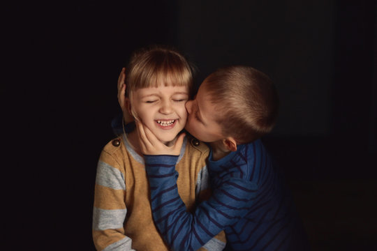 Little boy kisses a beautiful girl.