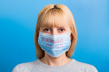 Portrait of a woman in medical mask with stop coronavirus text at blue background. Coronavirus concept. Respiratory protection