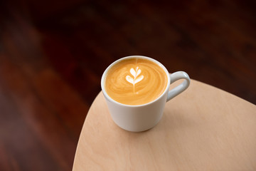 hot latte coffee in white ceramic on wooden table in coffee shop