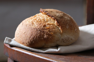 Fresh homemade bread on a wooden chair. French bread. Sourdough bread. Unleavened bread