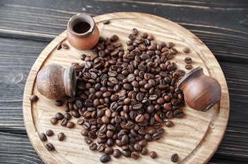 coffee beans with clay pot on a wooden tray, dark background