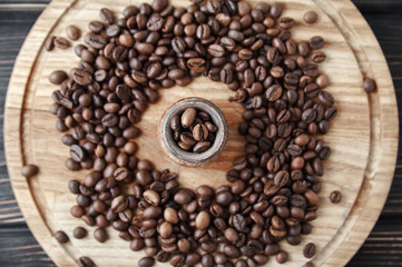 coffee beans with clay pot on a wooden tray, dark background