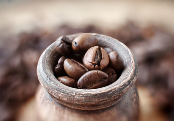 coffee beans with clay pot on a wooden tray, dark background