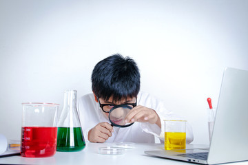 Elementary school boy wearing white dress, doing scientific experiments in the laboratory. Concepts of child education development