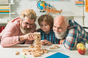 Grandfather father and pupil son smiling against home background. Happy generational muti three...