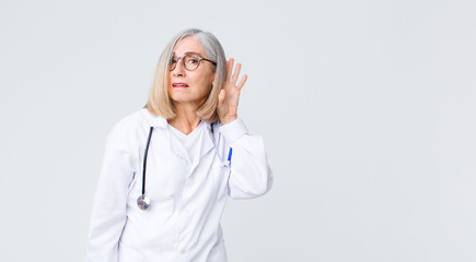 middle age doctor woman looking serious and curious, listening, trying to hear a secret...