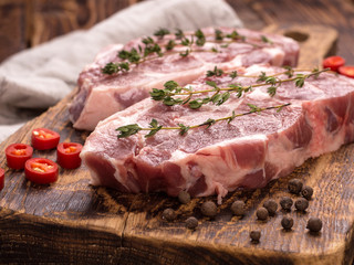fresh pork steak on wooden background.