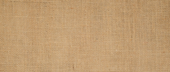 Fototapeta na wymiar Hessian sackcloth burlap woven texture background / cotton woven fabric background with flecks of varying colors of beige and brown. with copy space. office desk concept.