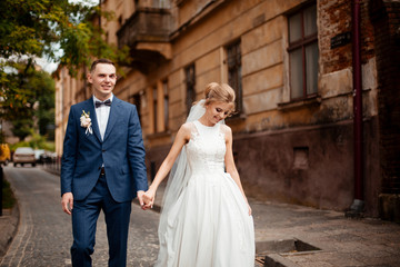 Naklejka premium gorgeous wedding couple walking in the old city