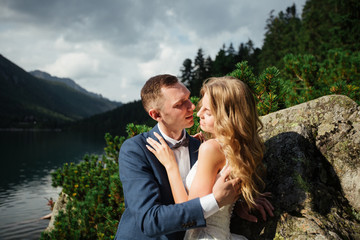 Happy bride and groom on their wedding. The groom kisses the forehead of the bride. Portrait of the bride. Newlyweds in the park. Happy couple. Wedding photo. Couple in love.