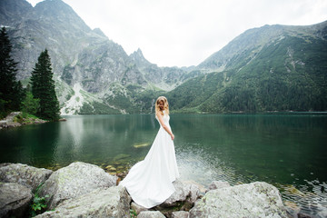 Portrait of a beautiful bride with a wedding bouquet. Blonde girl with curly hair and fashion...