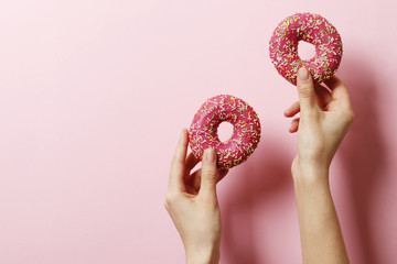 Woman holding delicious donut on color background