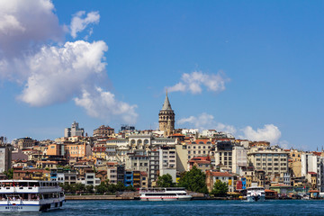 Fototapeta premium June 18, 2019 - Istanbul, Turkey - View of Galata Tower from the opposite bank on the Golden Horn, ferry boats are in the foreground