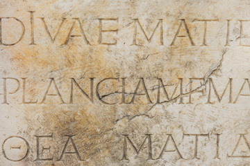 Ancient wall and letters curved in its surface.