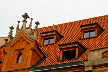 Prague. 05.10.2019: Low light detail of patina red roof top. Prague Lesser Town typical roofing material. Old roofing of clay tiles. Various orange shades and stains.