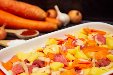 meat with vegetables in a baking dish close-up