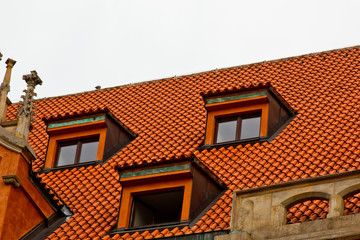 Prague. 05.10.2019: Low light detail of patina red roof top. Prague Lesser Town typical roofing material. Old roofing of clay tiles. Various orange shades and stains.