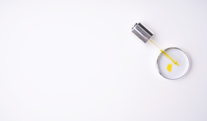 Dropper with moisturizing cosmetic oil on the cap isolated on a white background.