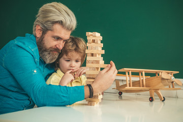 Father and son playing stacking wood blocks Jenga games for meditation practice. Hand movement control Building Computational Skills. Children's play concept.