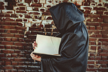 black monk with a book in a cloak