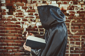 black monk with a book in a cloak