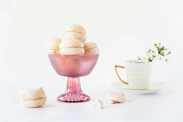 Marshmallows in a vase.Tea cup with flowers.White background.Minimalism.