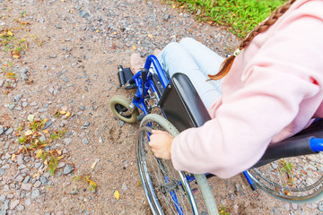 Hand handicap woman in wheelchair wheel on road in hospital park waiting for patient services....