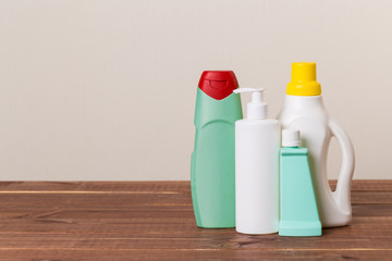 Cleaning product plastic container for house clean on wooden table and gray background . household chemicals