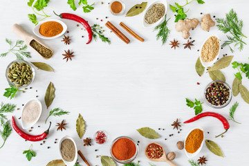 Various assorted colorful spices and herbs on white wooden background top view.