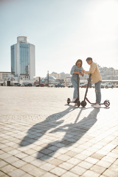 Self ride at your own selected place. Friends using electric scooter on a sunny day