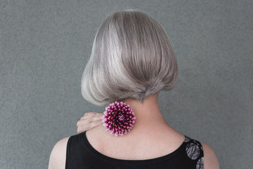 Lady with beautiful silver hair and red dahlia