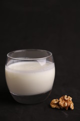glass of walnut milk in color background