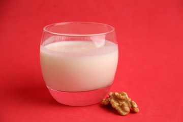 glass of walnut milk in color background