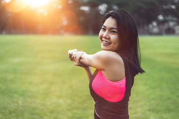 Women perform exercises by focusing on their hands and arms before exercising in the park.