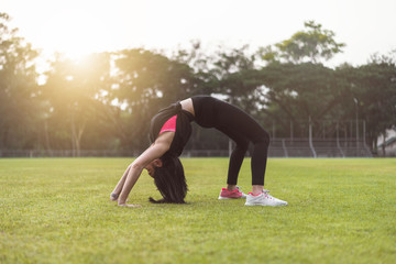 Women perform exercises by focusing on the torso and back muscles before exercising in the park.