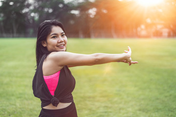 Women perform exercises by focusing on their hands and arms before exercising in the park.