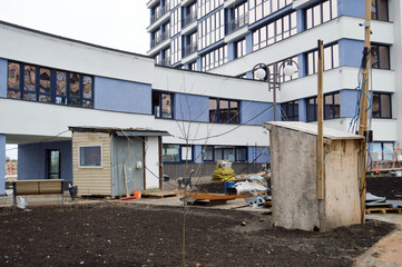 Obraz premium View near the entrance of the house during the repair of the construction of the exterior decoration of the facade of the new building in the big city of megalopolis