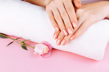 Obraz na płótnie Canvas Beautiful Woman Hands with fresh eustoma. Spa and Manicure concept. Female hands with pink manicure. Soft skin, skincare concept. Beauty nails. Over beige background