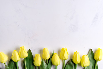 Amazing spring yellow tulip flowers on stone background, flat lay with copy space